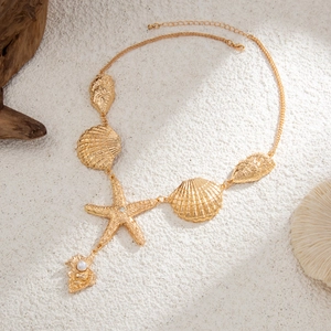 Dettaglio ravvicinato della collana marina dorata con stelle marine e conchiglie