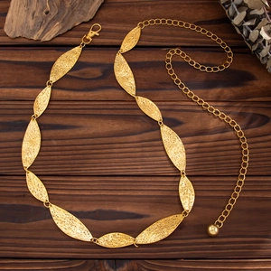 Eleganter goldener Metall-Taillenkette mit strukturierten Blattplatten auf Holzgrund