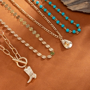 Detail von böhmischen Goldhalsketten mit Westernstiefel, Cowboyhut und türkisfarbenen Perlen
