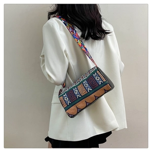 Vue détaillée d'un sac bandoulière ethnique coloré avec une large sangle portée au dos
