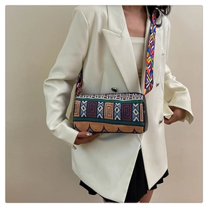 Sac seau ethnique à rayures avec large bandoulière bohème sur un blazer blanc
