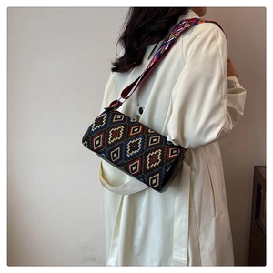 Détail sac seau ethnique avec motifs géométriques et large bandoulière tissée