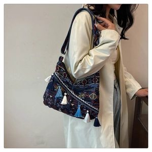 Close-up of bohemian shoulder bag with ethnic geometric patterns and colorful tassels