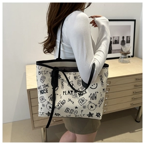 Model view of large graffiti print tote bag with black shoulder straps and street style art