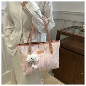Detalle del bolso tote de jacquard rosa con bordado y tierno colgante de nube suave