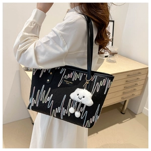 Black canvas tote bag with colorful zigzag embroidery and a white cloud charm