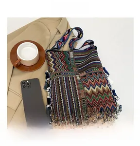 Detail of bohemian tote bag with colorful geometric patterns and blue fringe trim