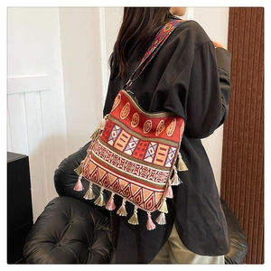 Detail of bohemian tote bag with jacquard ethnic patterns and colorful tassels
