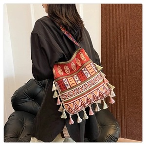 Detail of bohemian tote bag with vibrant ethnic patterns and long colorful tassels