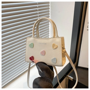 Detail of cream mini crossbody bag with colorful stitched hearts and FASHION lettering