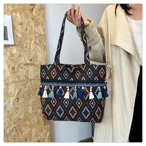 Detailed view of bohemian tote bag with blue tassels and geometric diamond weaving