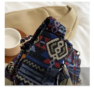 Close-up of ethnic woven shoulder bag showing colorful textures and gold metal ring