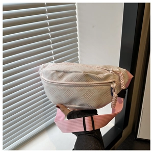 Détail de la texture matelassée rose clair et de la bandoulière en nylon du sac bandoulière