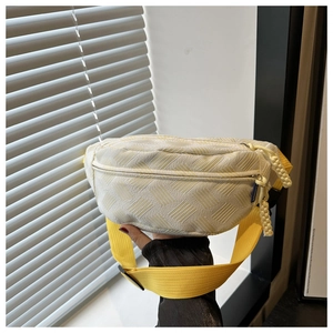 Détail du sac de poitrine en nylon texturé crème avec bandoulière jaune vif