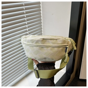 Détail du tissu texturé vert clair et de la tirette de fermeture éclair tissée du sac