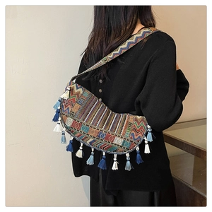 Detailed back view of a colorful ethnic tapestry crossbody bag with blue cotton tassels