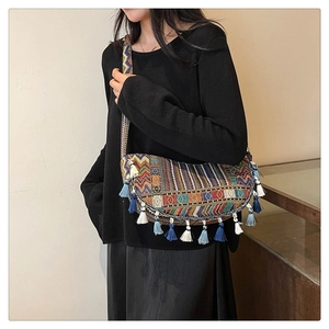 Close-up of bohemian shoulder bag featuring colorful tapestry and vibrant blue cotton tassels