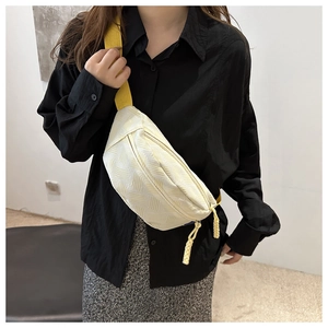 Détail du sac banane jaune clair texturé avec motifs en relief et sangle réglable