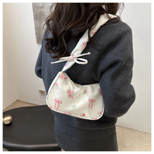 Close-up of white underarm bag featuring pink rose patterns and cute decorative bows