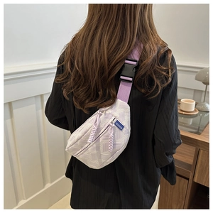 Détail du sac bandoulière en nylon à damier violet et blanc avec sangle et fermeture éclair