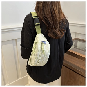 Détail d'un sac de poitrine tissé tendance avec sangle réglable et étiquette de mode