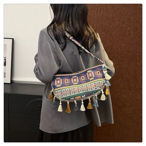 Detail of colorful geometric woven pattern and long tassels on ethnic crossbody bag
