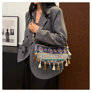 Detail of vintage bohemian crossbody bag featuring intricate tassels and woven ethnic strap