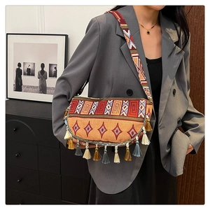 Detail of bohemian fringe crossbody bag featuring ethnic embroidery and woven strap