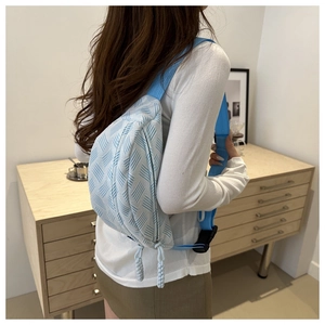 Détail du sac de poitrine bleu clair tissé avec double fermeture et sangle large