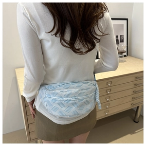 Détail du sac de poitrine en nylon bleu clair avec motif géométrique tissé et cordon