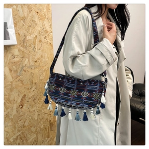 Close-up of ethnic hobo bag featuring geometric weaving and long tassel details