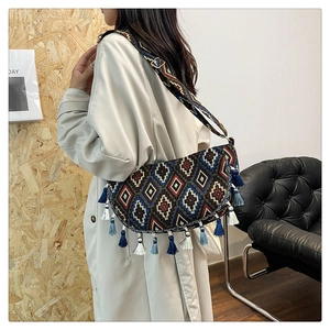 Detailed side view of ethnic tassel crossbody bag with geometric patterns and fringe