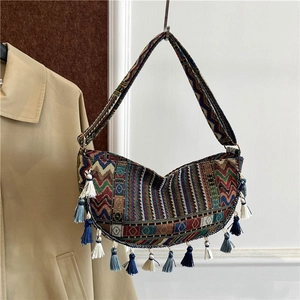 Bohemian style woven shoulder bag with colorful ethnic patterns and long dynamic tassels