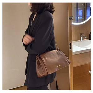 Close-up of brown glossy shoulder bag with metal chain and Fashion Bags logo text