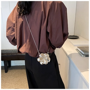 Creative 3D floral metal chain bag worn on a model back showing mirror silver petals