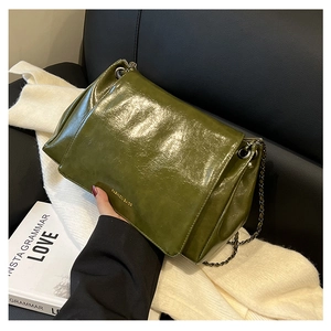 Detail of olive green crinkled texture leather bag with vintage bronze chain strap