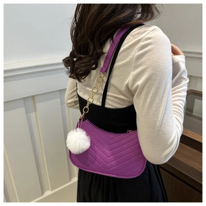 Purple quilted faux leather shoulder bag with gold chain and white pompom on model