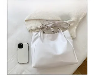 Detailed top view of a white tote bag interior capacity with leather texture and silver rings