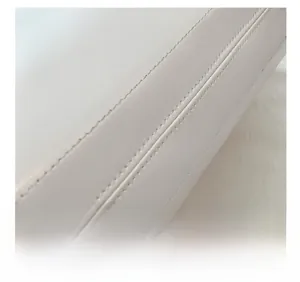 Close-up of precise stitching and smooth leather texture on white large tote bag
