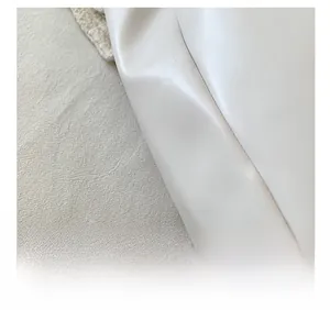 Detailed macro view of white leather tote bag featuring precise stitching and texture