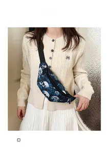 Detail of crossbody chest bag with blue skull and floral print worn by a model