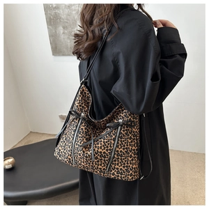 Dettaglio della borsa tote leopardata con zip argentate e fiocchi decorativi neri