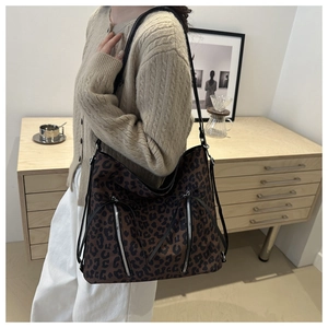 Détail du grand sac cabas léopard avec poches à fermeture éclair et lanières en cuir