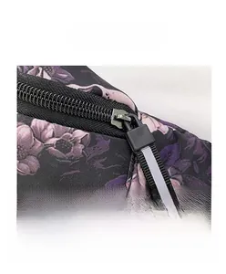 Macro detail of dark floral nylon waist bag featuring a black metal zipper and reflective puller