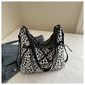 Dettaglio della borsa tote leopardata con fiocchi neri e tracolle in pelle
