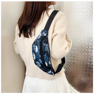 Detail view of navy blue nylon fanny pack with white skull and blue floral pattern print