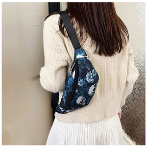 Detail of adjustable strap and skull print on navy chest bag shown on model