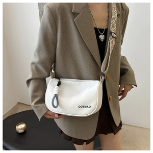 Détail du sac bandoulière en nylon blanc avec large sangle ethnique et logo OOTMAO noir