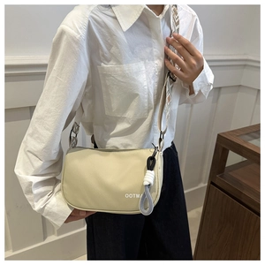 Détail du sac bandoulière en toile beige avec sangle tissée et design du logo OOTMA