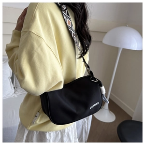 Detail of black crescent crossbody bag with ethnic geometric pattern wide shoulder strap